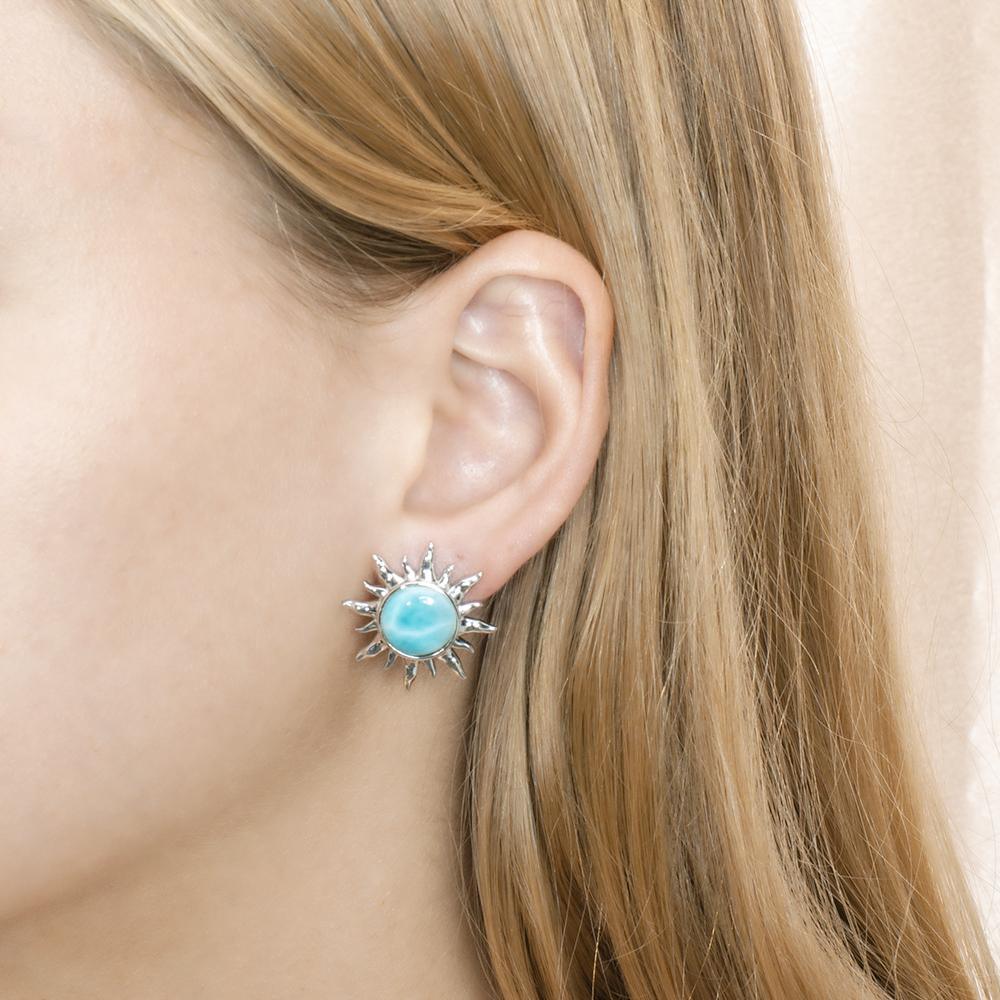 In this photo there is a model wearing a 925 sterling silver sun stud earring with a blue larimar gemstone