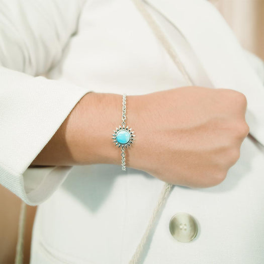 In this photo there is a model wearing a 925 sterling silver sunflower bracelet with one larimar gemstone.