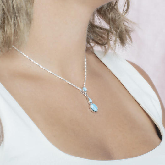 The picture shows a model wearing a 925 sterling silver larimar pendant featuring two circles and a teardrop in the center.