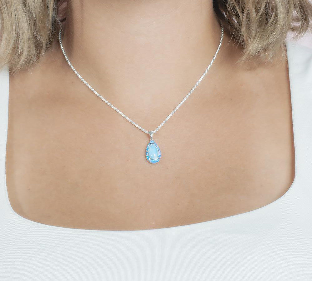 The picture shows a model wearing a 925 sterling silver larimar teardrop pendant.