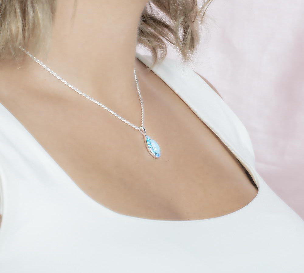 The picture shows a model wearing a 925 sterling silver larimar teardrop pendant.