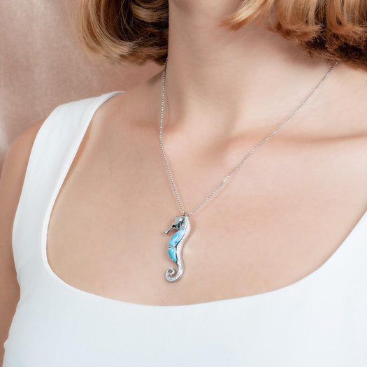 The picture shows a model wearing a 925 sterling silver larimar seahorse pendant.