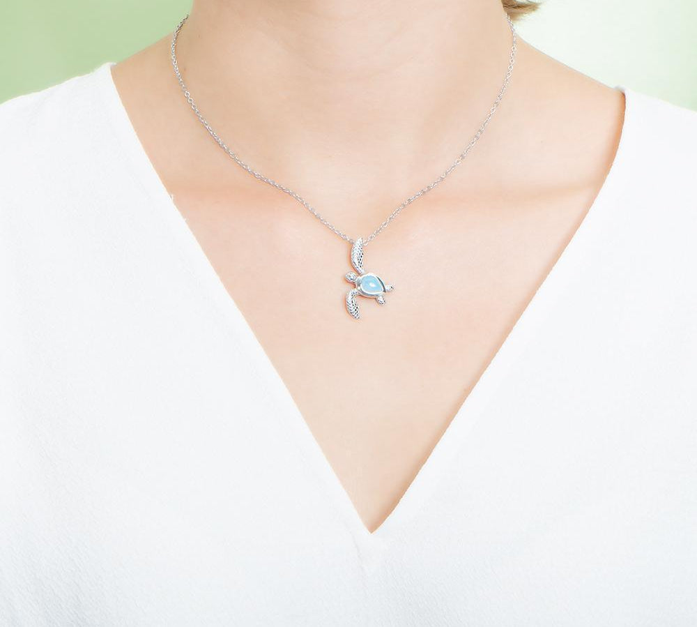 The picture shows a model wearing a 925 sterling silver larimar sea turtle pendant.