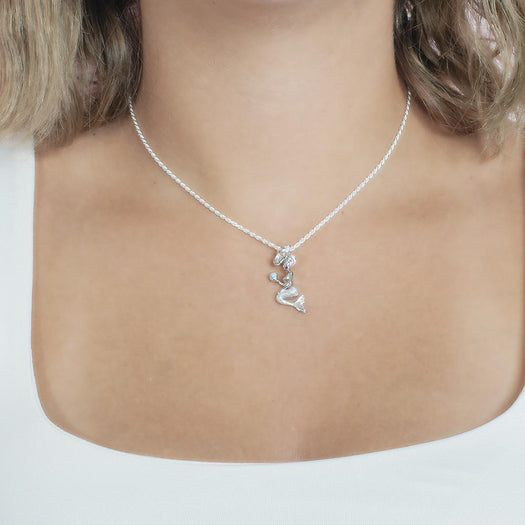 The picture shows a model wearing a small 925 sterling silver larimar wishing mermaid pendant.