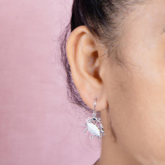 The picture shows a model wearing a 925 sterling silver blue crab hook earring.