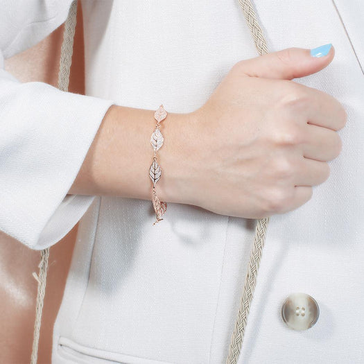 In this photo there is a model wearing a rose gold plated maile leaf bracelet with cubic zirconia.