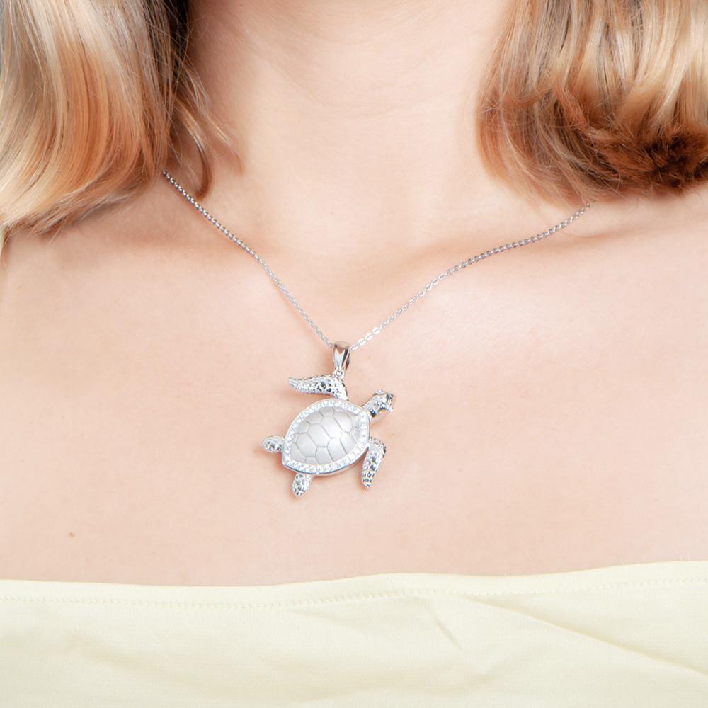 The picture shows a model wearing a 925 sterling silver sea turtle pendant with topaz.