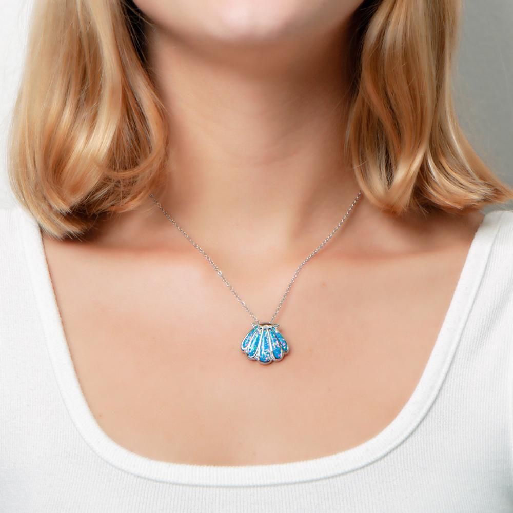 The picture shows a model wearing a 925 sterling silver oyster shell pendant with opalite and topaz.