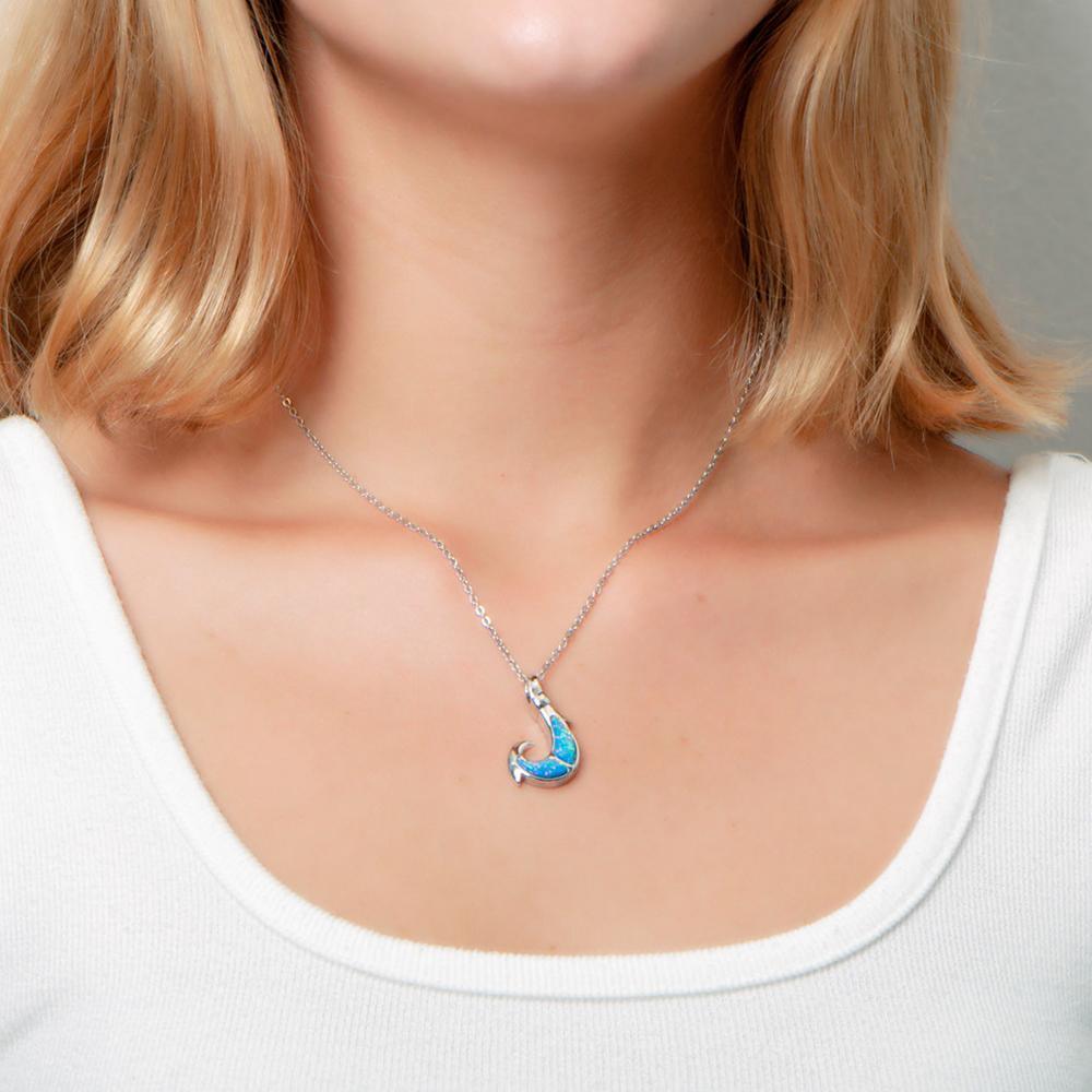 In this photo there is a model with blonde hair and a white shirt, wearing a sterling silver fish hook pendant with blue opalite gemstones.