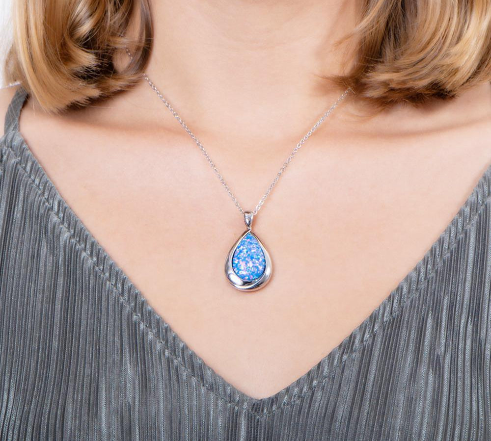 The picture shows a model wearing a 925 sterling silver opalite teardrop pendant.