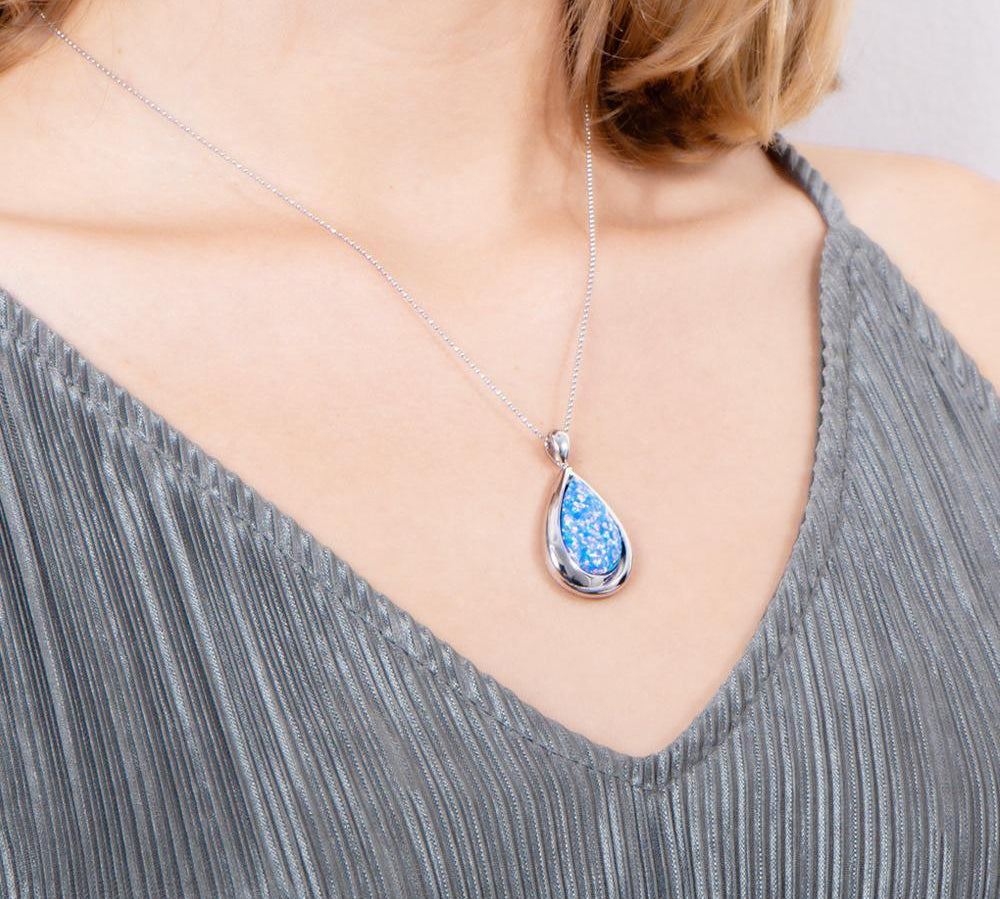 The picture shows a model wearing a 925 sterling silver opalite teardrop pendant.