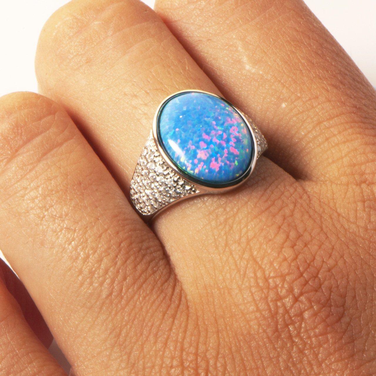 This photo shows a model wearing a 925 sterling silver cocktail ring paired with an oval opalite gemstone and high quality cubic zirconia