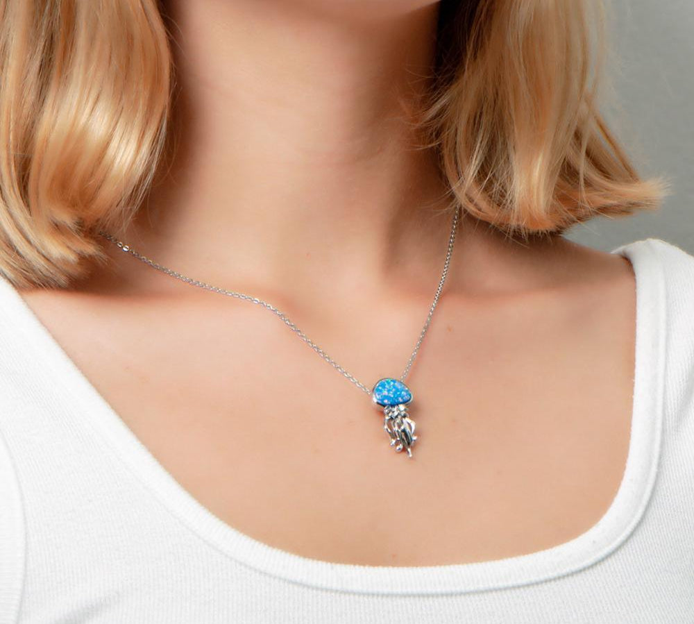 The picture shows a model wearing a 925 sterling silver opalite button jellyfish pendant.