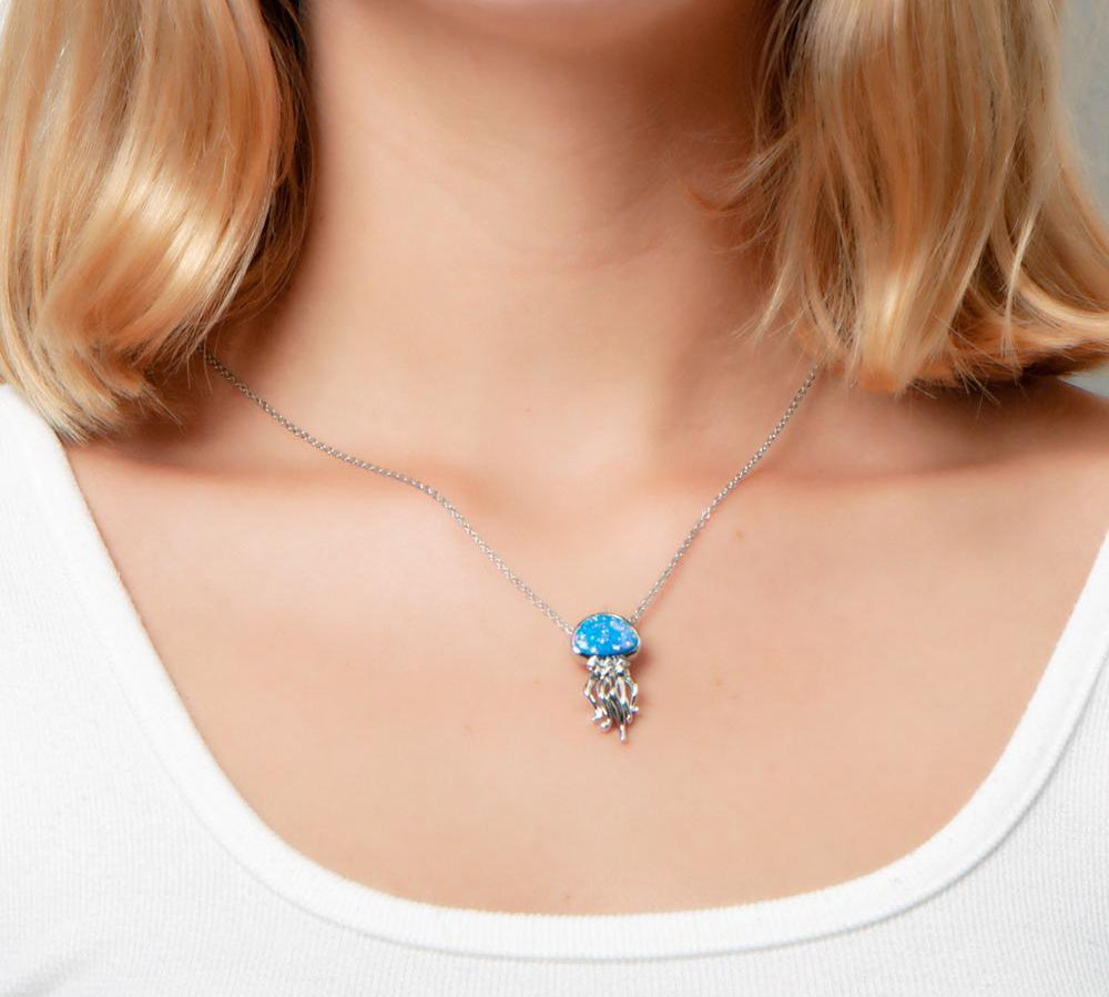 The picture shows a model wearing a 925 sterling silver opalite button jellyfish pendant.