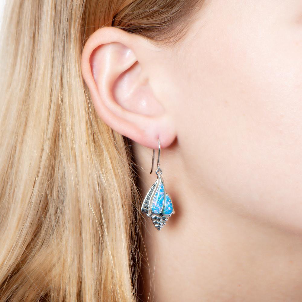The picture shows a model wearing a 925 sterling silver opalite conch shell earring.