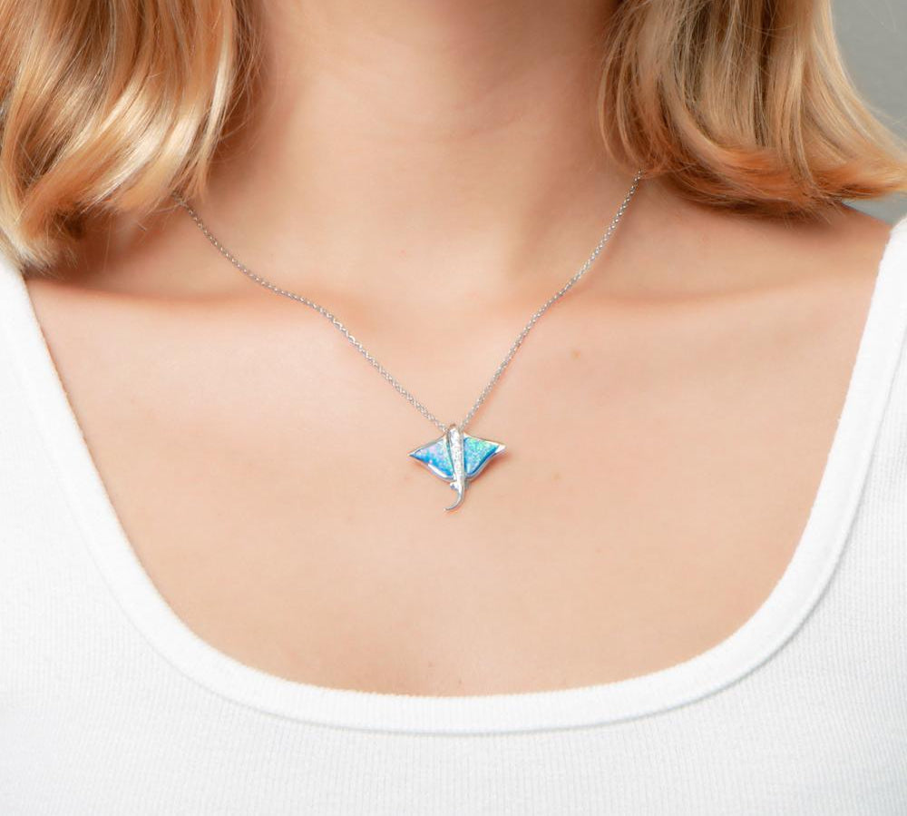 The picture shows a model wearing a 925 sterling silver opalite eagle ray pendant with cubic zirconia.