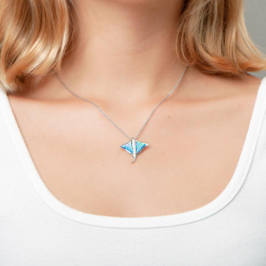 The picture shows a model wearing a 925 sterling silver opalite eagle ray pendant with cubic zirconia.