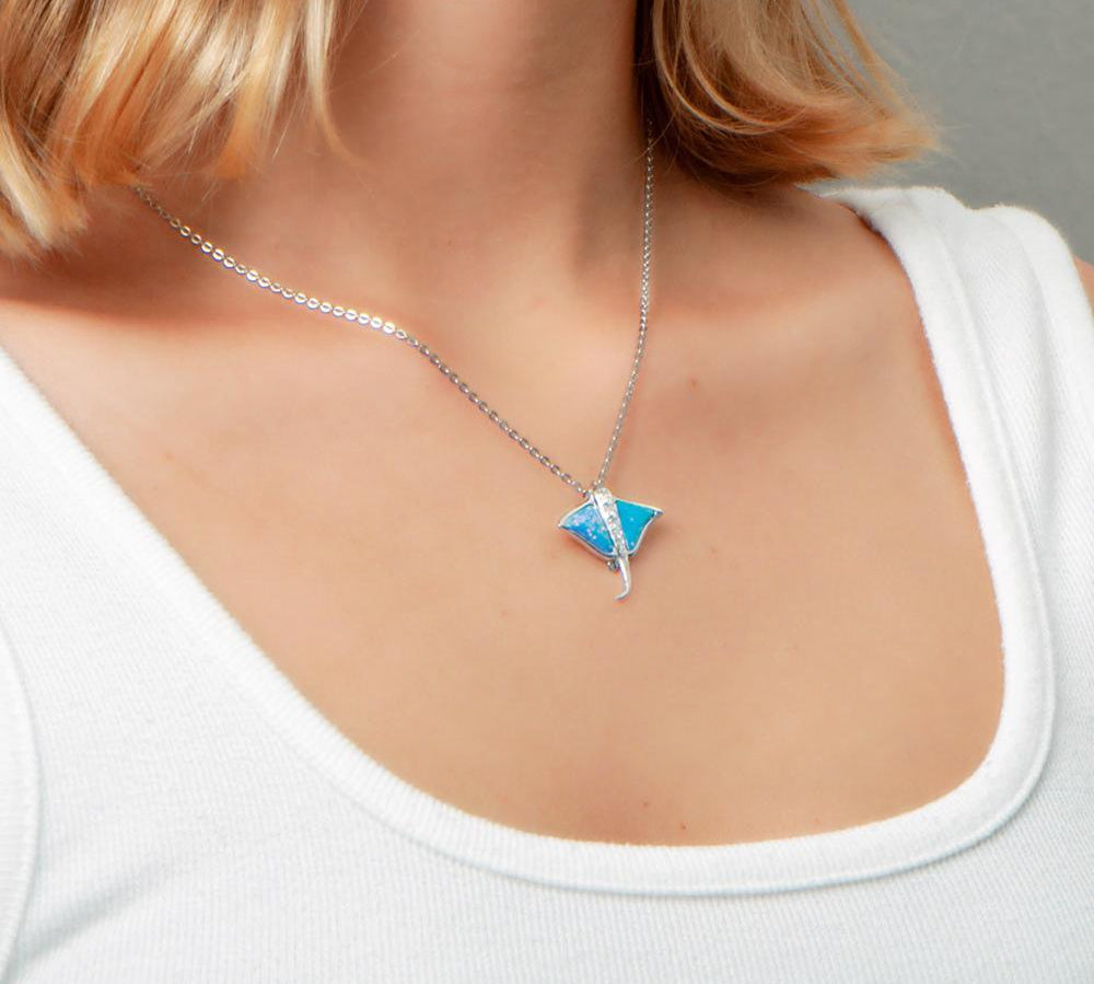 The picture shows a model wearing a 925 sterling silver opalite eagle ray pendant with cubic zirconia.