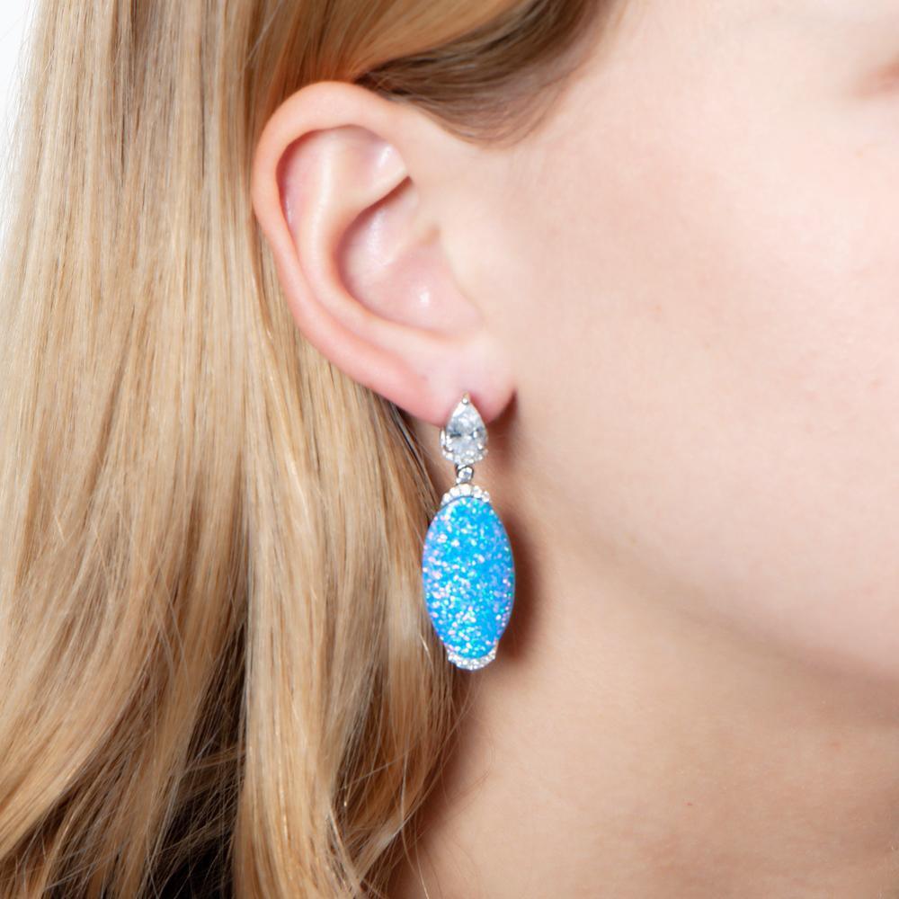 The photo shows a model wearing a sterling silver opalite earring with topaz and cubic zirconia.