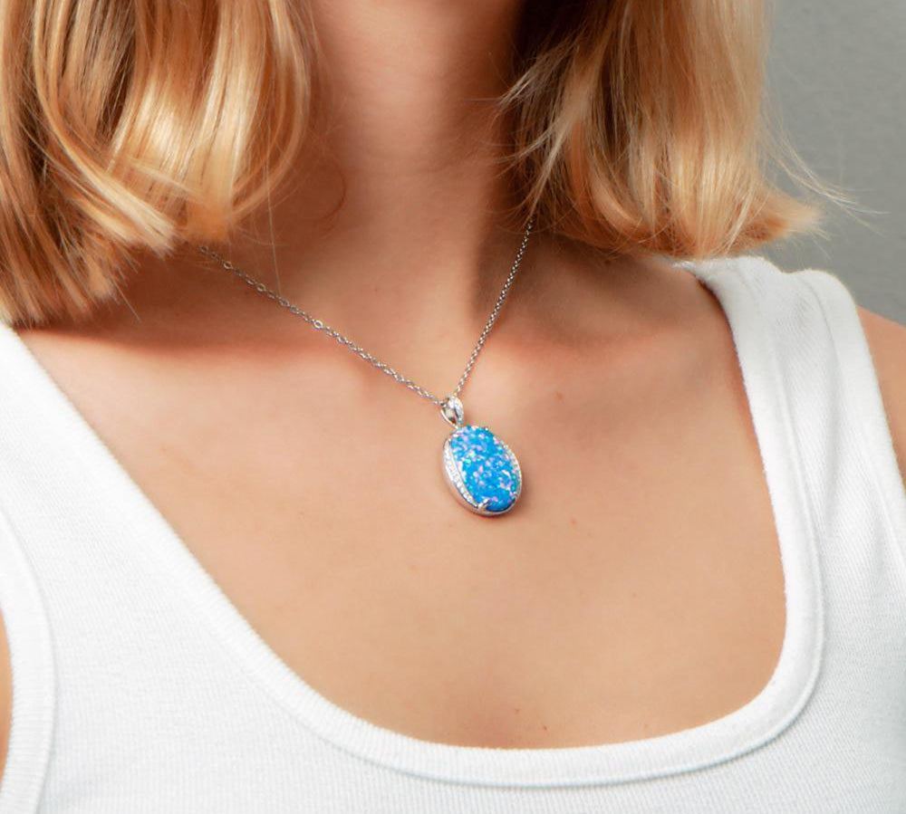 The picture shows a model wearing a 925 sterling silver opalite eclipse pendant with cubic zirconia.