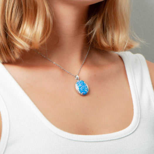 The picture shows a model wearing a 925 sterling silver opalite eclipse pendant with cubic zirconia.