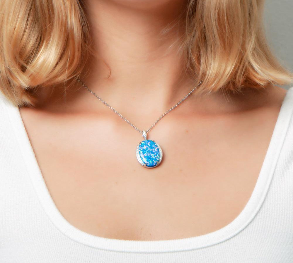 The picture shows a model wearing a 925 sterling silver opalite eclipse pendant with cubic zirconia.