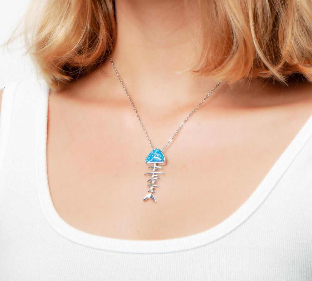 The picture shows a model wearing a 925 sterling silver opalite fish bone pendant.