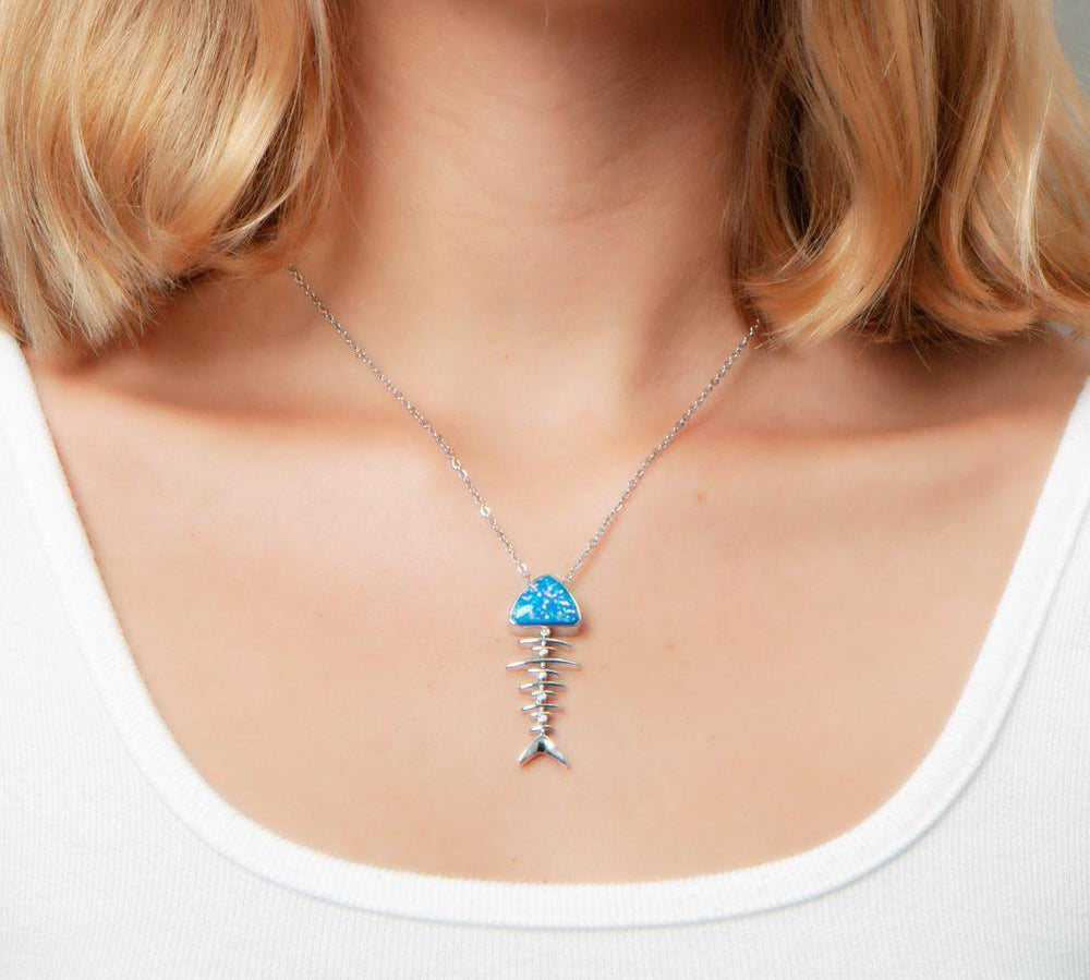 The picture shows a model wearing a 925 sterling silver opalite fish bone pendant.