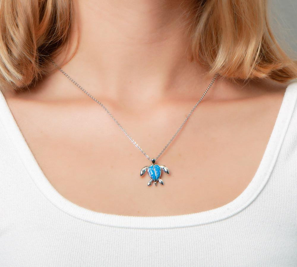 The picture shows a model wearing a 925 sterling silver opalite sea turtle pendant.