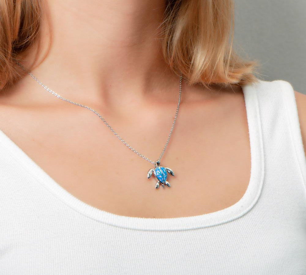 The picture shows a model wearing a 925 sterling silver opalite sea turtle pendant.