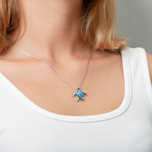 The picture shows a model wearing a 925 sterling silver opalite sea turtle pendant.