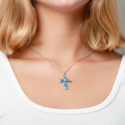 The picture shows a model wearing a 925 sterling silver opalite cross pendant with cubic zirconia.
