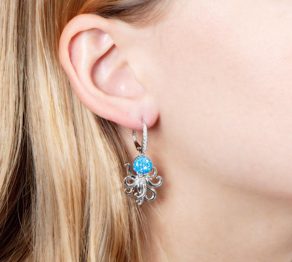 The picture shows a model wearing a 925 sterling silver opalite octopus earring with cubic zirconia.