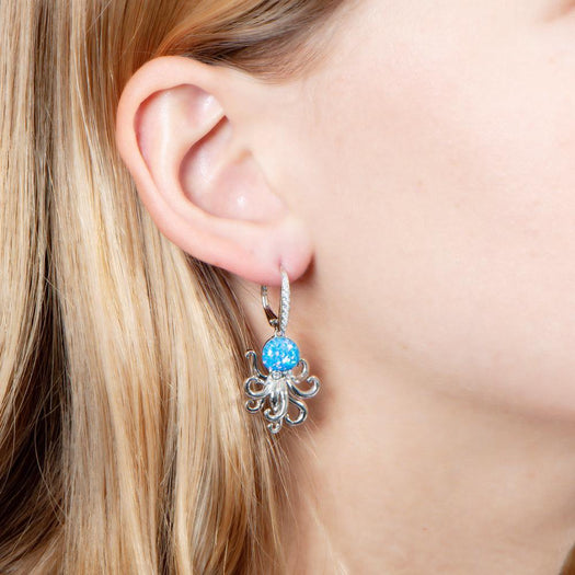 The picture shows a model wearing a 925 sterling silver opalite octopus earring with cubic zirconia.