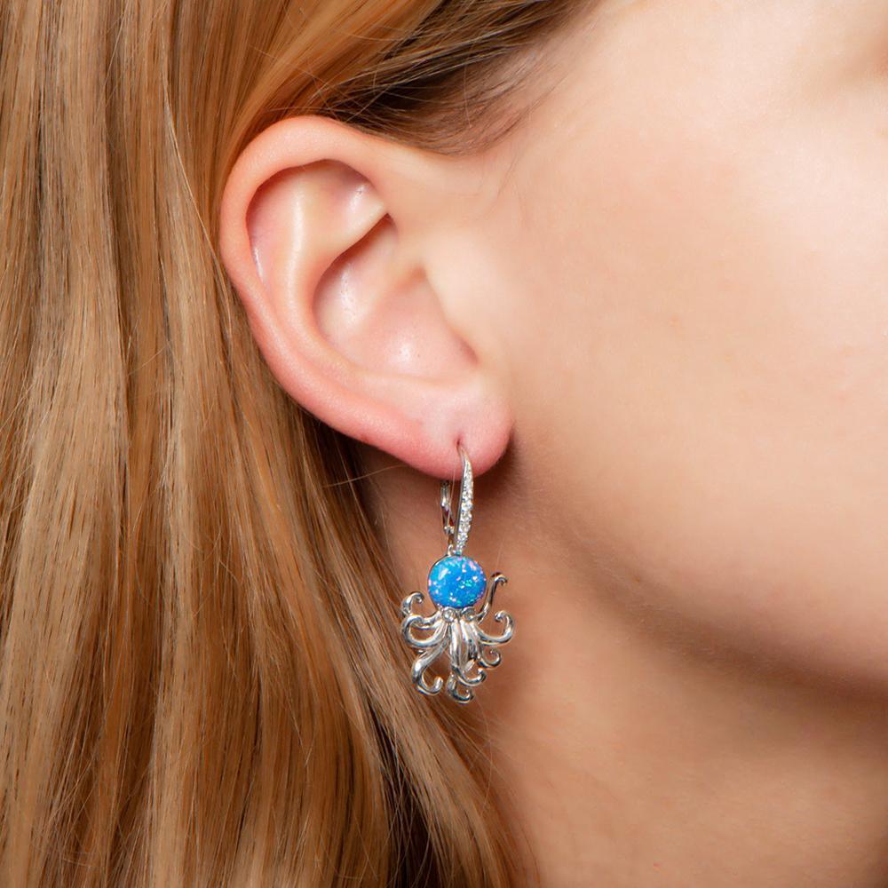 The picture shows a model wearing a 925 sterling silver opalite octopus earring with cubic zirconia.