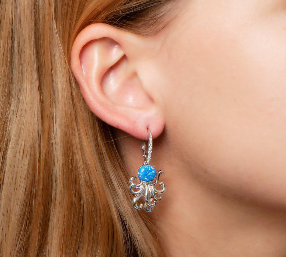 The picture shows a model wearing a 925 sterling silver opalite octopus earring with cubic zirconia.