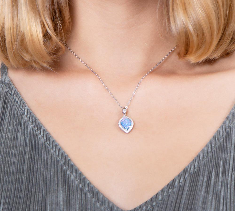 The picture shows a model wearing a 925 sterling silver opalite mandorla pendant with cubic zirconia.