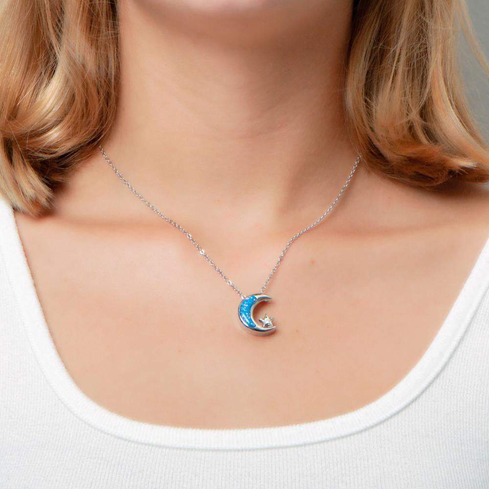 The picture shows a model wearing a 925 sterling silver opalite moon and star pendant with topaz.