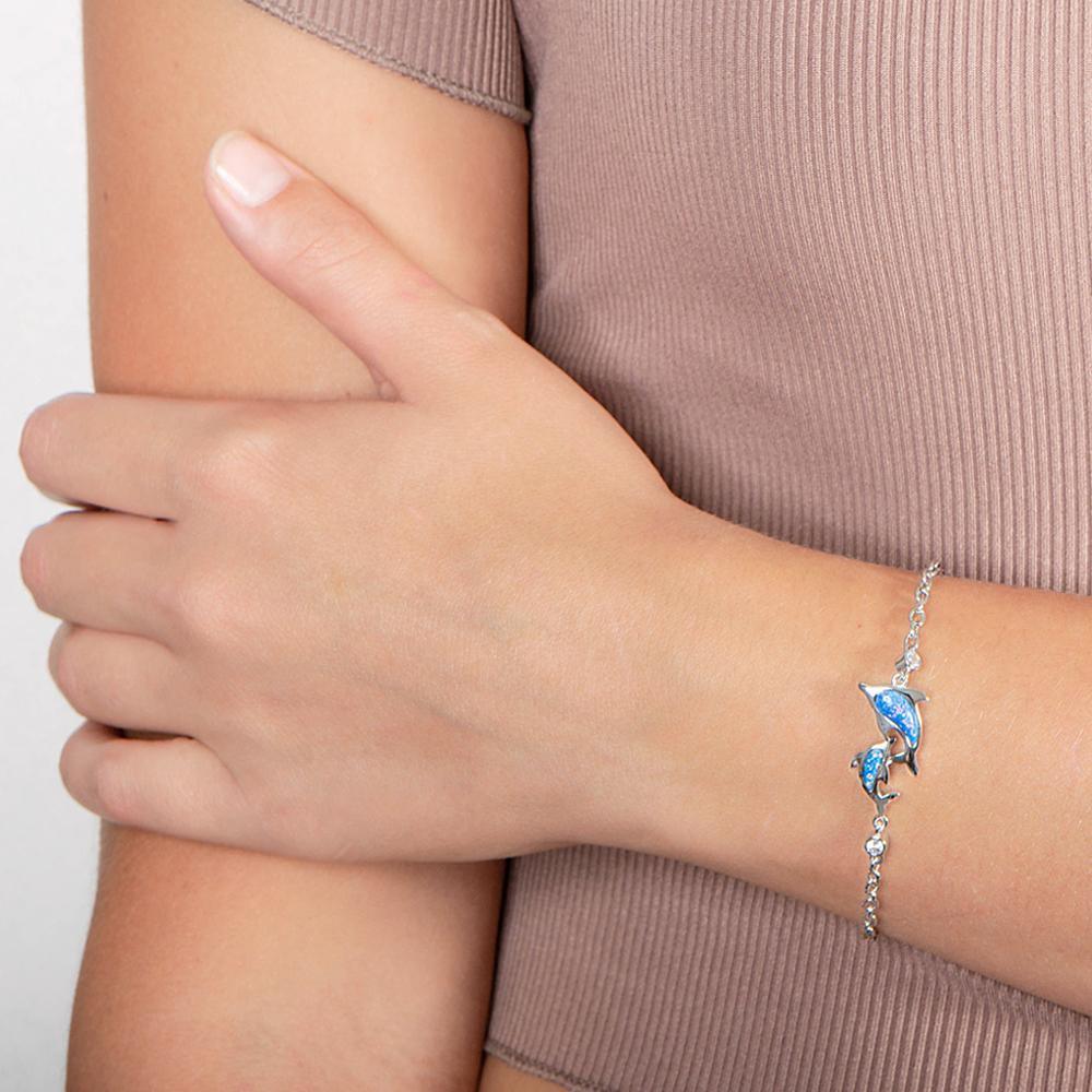 The picture shows a model wearing a 925 sterling silver opalite two dolphin lovers bracelet with cubic zirconia.