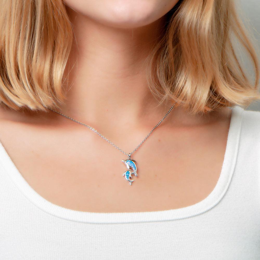 The picture shows a model wearing a 925 sterling silver opalite two dolphin lovers pendant.