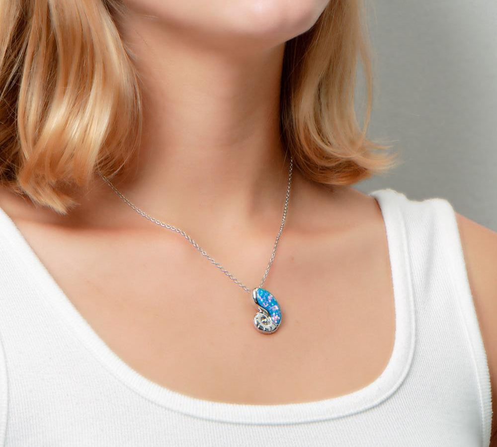 The picture shows a model wearing a 925 sterling silver opalite nautilus pendant.