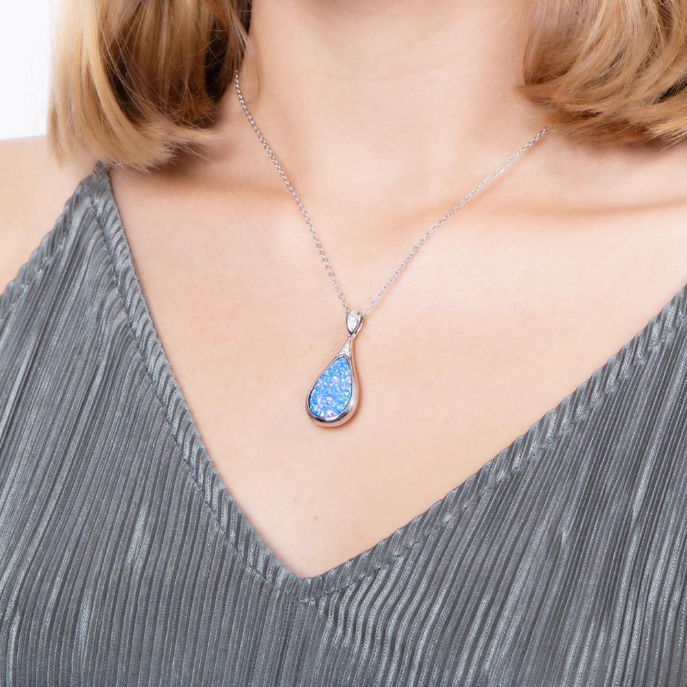 The picture shows a model wearing a 925 sterling silver opalite teardrop pendant with topaz.