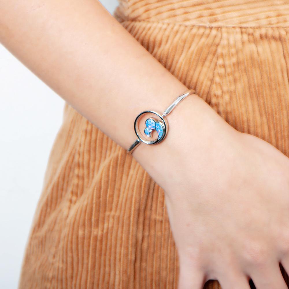 In this photo there is a model wearing a 925 sterling silver big wave bracelet with blue opalite gemstones