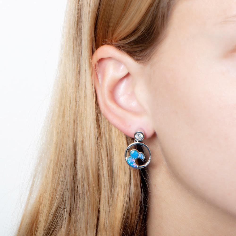 The picture shows a model wearing a 925 sterling silver opalite big wave earring with topaz.