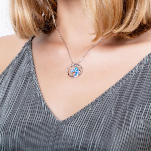 In this photo there is a model with blonde hair and a gray shirt, wearing a sterling silver big wave circle pendant with blue opalite gemstones. 