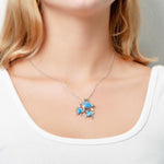 The picture shows a model wearing a 925 sterling silver opalite family of three sea turtles pendant with topaz.