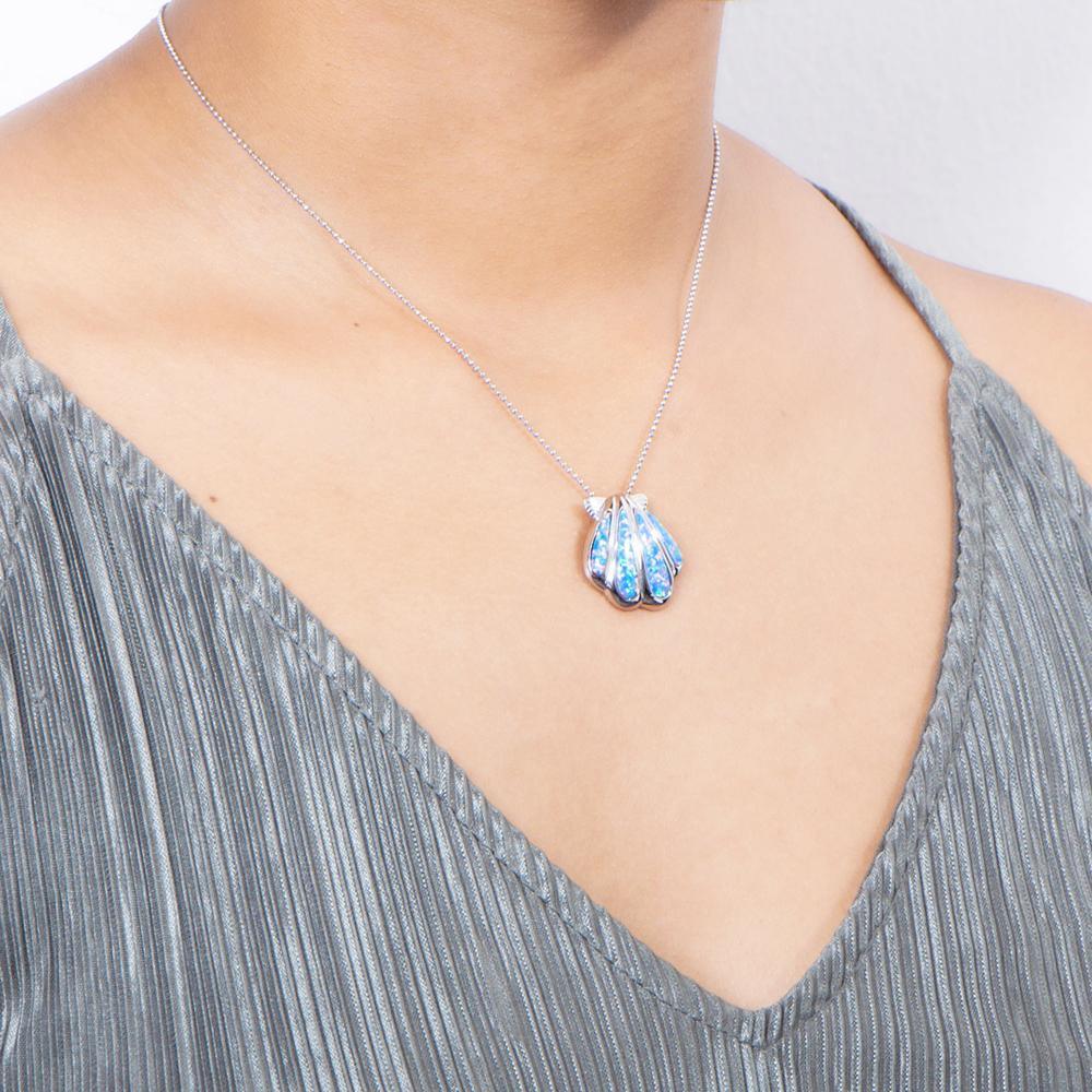 The picture shows a model wearing a 925 sterling silver opalite oyster shell pendant.