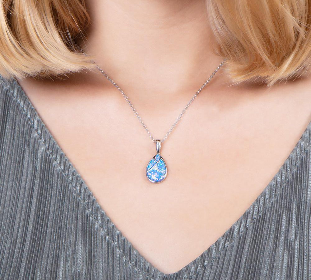 The picture shows a model wearing a 925 sterling silver pieces of opalite gems teardrop pendant with cubic zirconia.