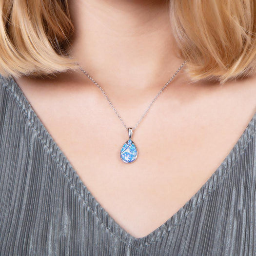 The picture shows a model wearing a 925 sterling silver pieces of opalite gems teardrop pendant with cubic zirconia.