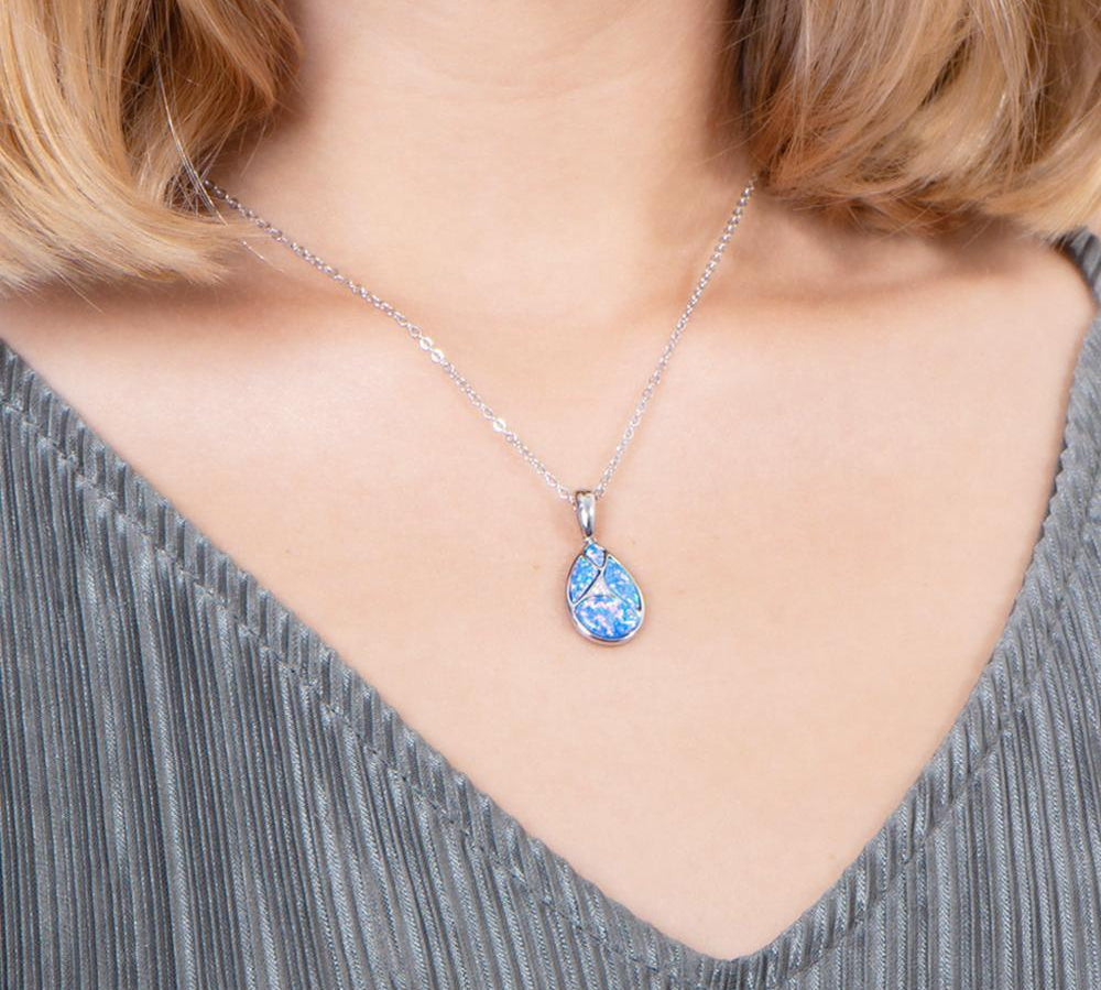 The picture shows a model wearing a 925 sterling silver pieces of opalite gems teardrop pendant with cubic zirconia.